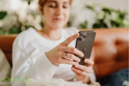 Frau mit Smartphone als Symbol für den Schutz digitaler Geräte durch eine Cyberversicherung.