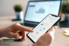 Person nutzt Smartphone mit Finanzdiagrammen als Symbol für moderne Investment-Apps und digitale Geldanlage.