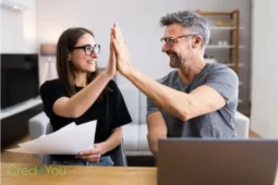 Paar gibt sich High-Five nach Finanzplanung, Symbol für den Umgang mit Steuern auf Investments.